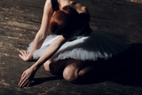 Young beautiful woman ballet dancer, dressed in professional outfit, pointe shoes and white tutu.
