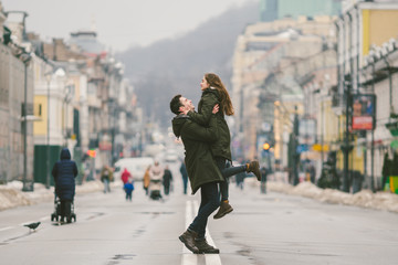 Young carefree happy people. Caucasian young students. Guy and girl. Love. Walk together on the european street in winter road. Theme love and happiness at a young age