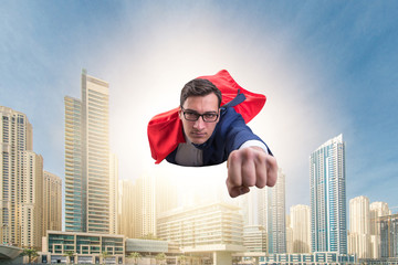 Superhero businessman flying over the city