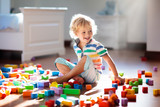 Child playing with colorful toy blocks. Kids play.