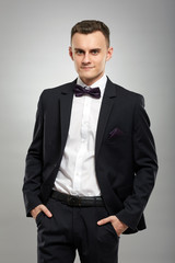 Young businessman on gray background