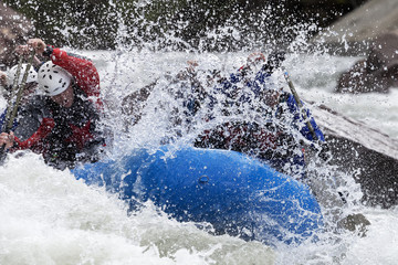 Brave people travel by raffting on a mountain river