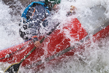 Brave people travel by raffting on a mountain river