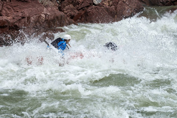 Brave people travel by raffting on a mountain river