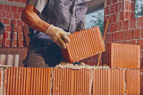 Real construction worker bricklaying the wall indoors.