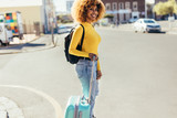 Tourist woman crossing the street holding luggage