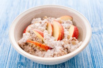 Homemade Porridge with Buckwheat jogurt and sliced apple in bowl