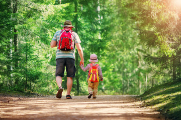 Father and boy going camping with tent in nature