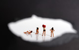 Miniature women changing clothes. The concept of stealthy criminal behavior.