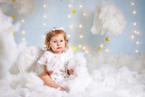 angel child is sitting the clouds looks down