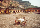 Outdoor restaurant with one table under walls of historical fort in Rajasthan. Rural cafe at breakfast time, India