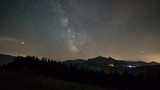 Milky way galaxy over mountains in starry night sky Time lapse