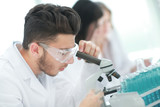 close up.man scientist looking through a microscope