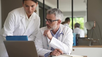 Medical people working together on patient file, hospital office