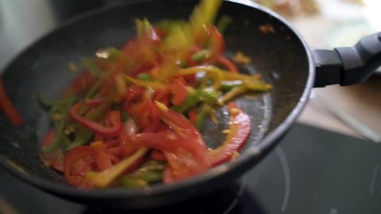 Closeup of food being cooked in fried pan (slow motion)