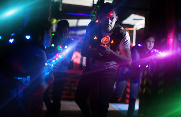 Excited guy laser tag player in bright beams
