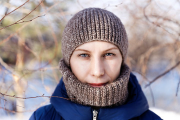 Winter closeup portrait of a young woman looking straight at the camera. Shallow focus.