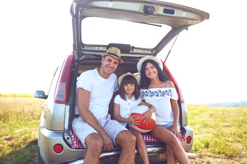 A happy family has a car on a summer trip.