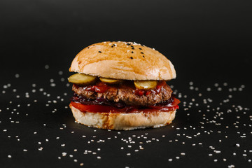 Tasty burger on the black background