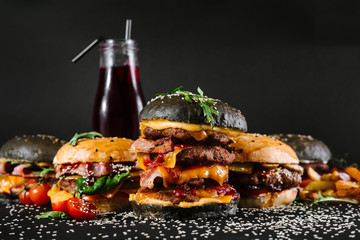Many different burgers with ingredients on a black background