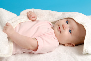 Baby girl lying on a white blanket