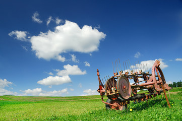 Agricultural machine on a green pasture