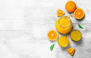 Orange juice in the pitcher and slices of fresh oranges.