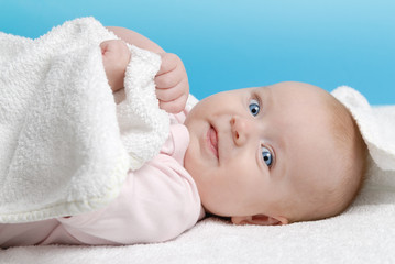 Baby girl lying on a white blanket