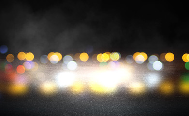 Dark empty stage, multicolored rays of neon searchlight, wet asphalt, smoke, night shooting, bokeh color.