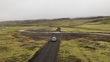 Aerial drone shot of SUV crossing a river ford in Highlands of Iceland