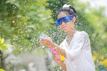 thai girl playing water splashing in song kran festival thailand new year concept