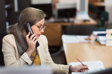 Attractive 30s woman working at office with telephone