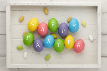 Colorful Easter eggs with letters on white planks