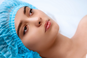 Young beautiful girl in spa salon. The girl lies on the couch for a massage after a rejuvenation procedure.