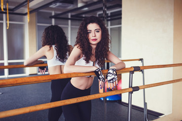 Young woman relaxing  gym after her workout. Female athlete taking rest after fitness training at gym