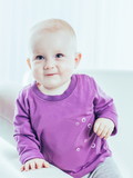 portrait of a happy one year old baby girl on a background of bright children's room