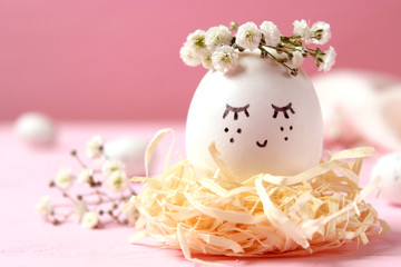  composition for Easter with a place to insert text. cute egg in a flower wreath and painted face.