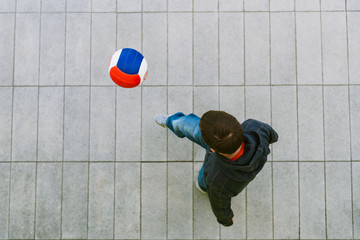 Young man practicing tricks with soccer ball