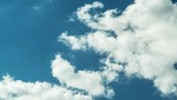White clouds float on the blue summer sky. Time-Lapse Motion 4K video.