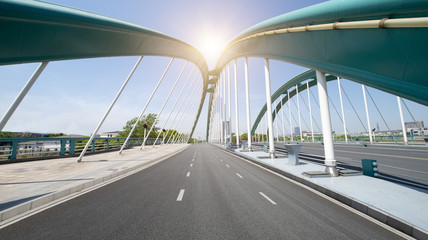  Asphalt highway under the urban steel frame bridge