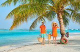 Family of three on beach under palm tree