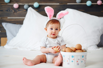 Portrait of adorable baby with bunny ears and easter basket