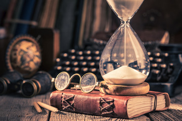 Hourglass and journal as memories of old journeys