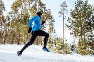 man runner running in cold weather in winter forest