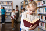 Preteen girl browsing textbook