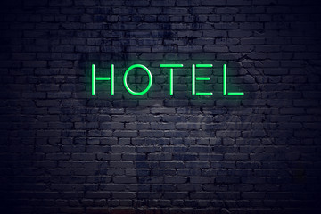 Brick wall at night with neon sign hotel
