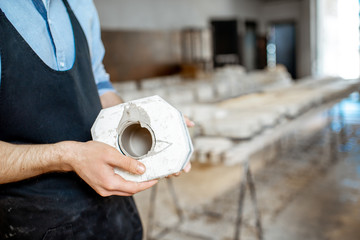 Man holding gypsum form at the pottery manufacturing, close-up view