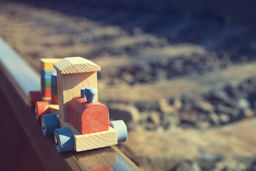 Children's wooden train on the railway, soft focus, toned