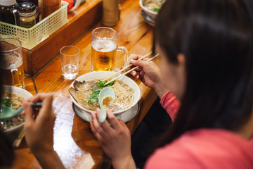 Two Japanese women friends eat ramen at local restaurant during quiet lunch