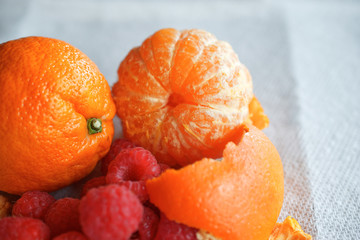 Whole peeled orange with raspberries